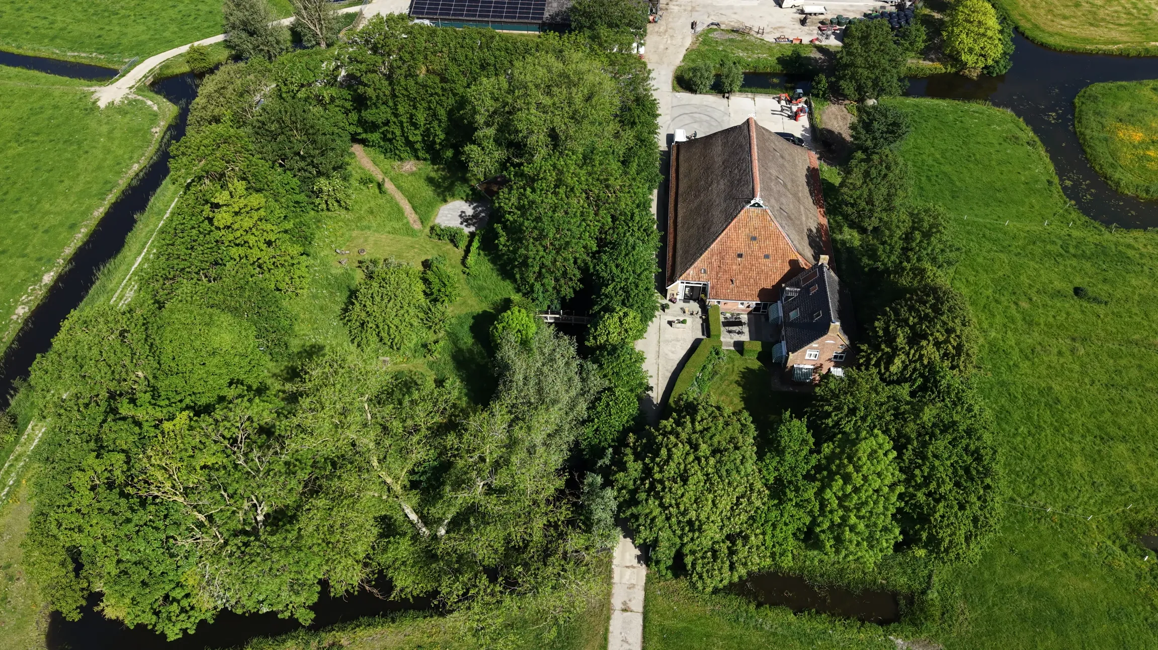 Luchtfoto van de boerderij, het erf en de omliggende weilanden