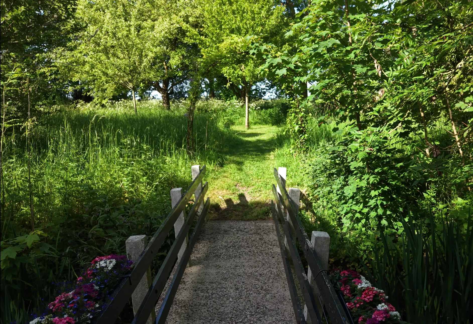 Het houten bruggetje met bloembakken naar het hof achter de boerderij