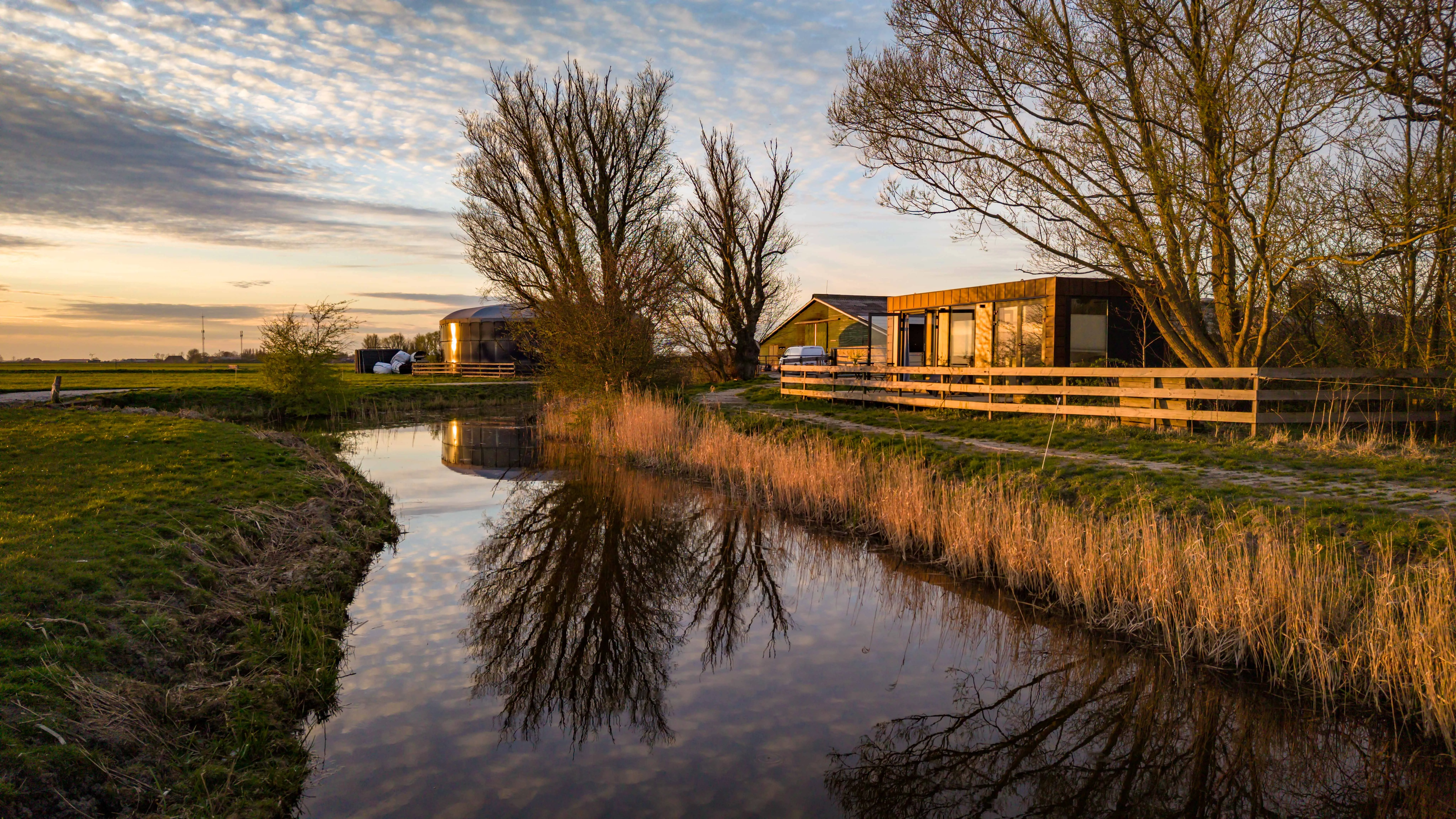 Het erf aan de vaart in het gouden avondlicht