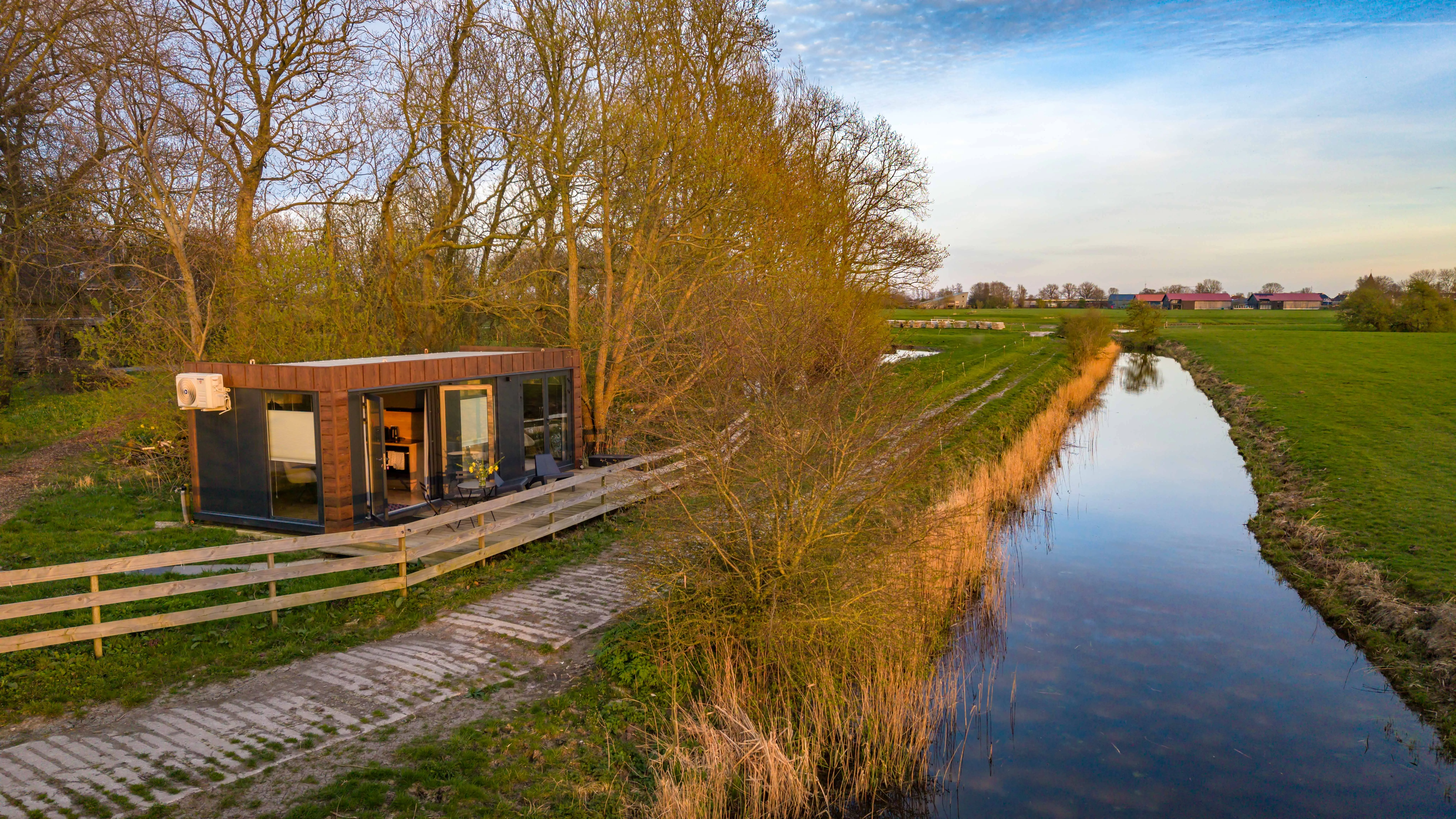 Het natuurhuisje aan de vaart vanuit de lucht bij zonsondergang