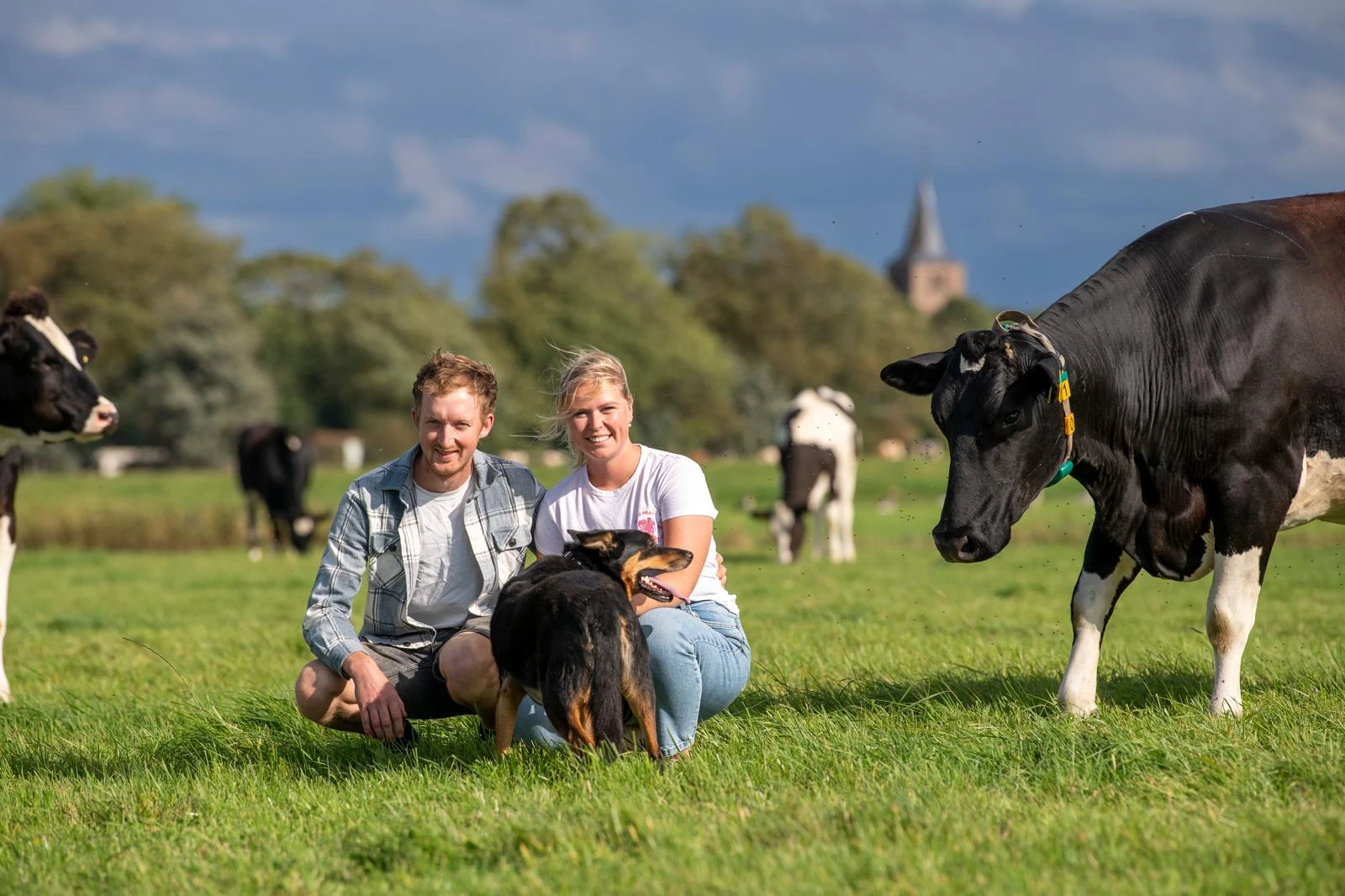 Sietse en Wimmie in het weiland met hun hond en de koeien