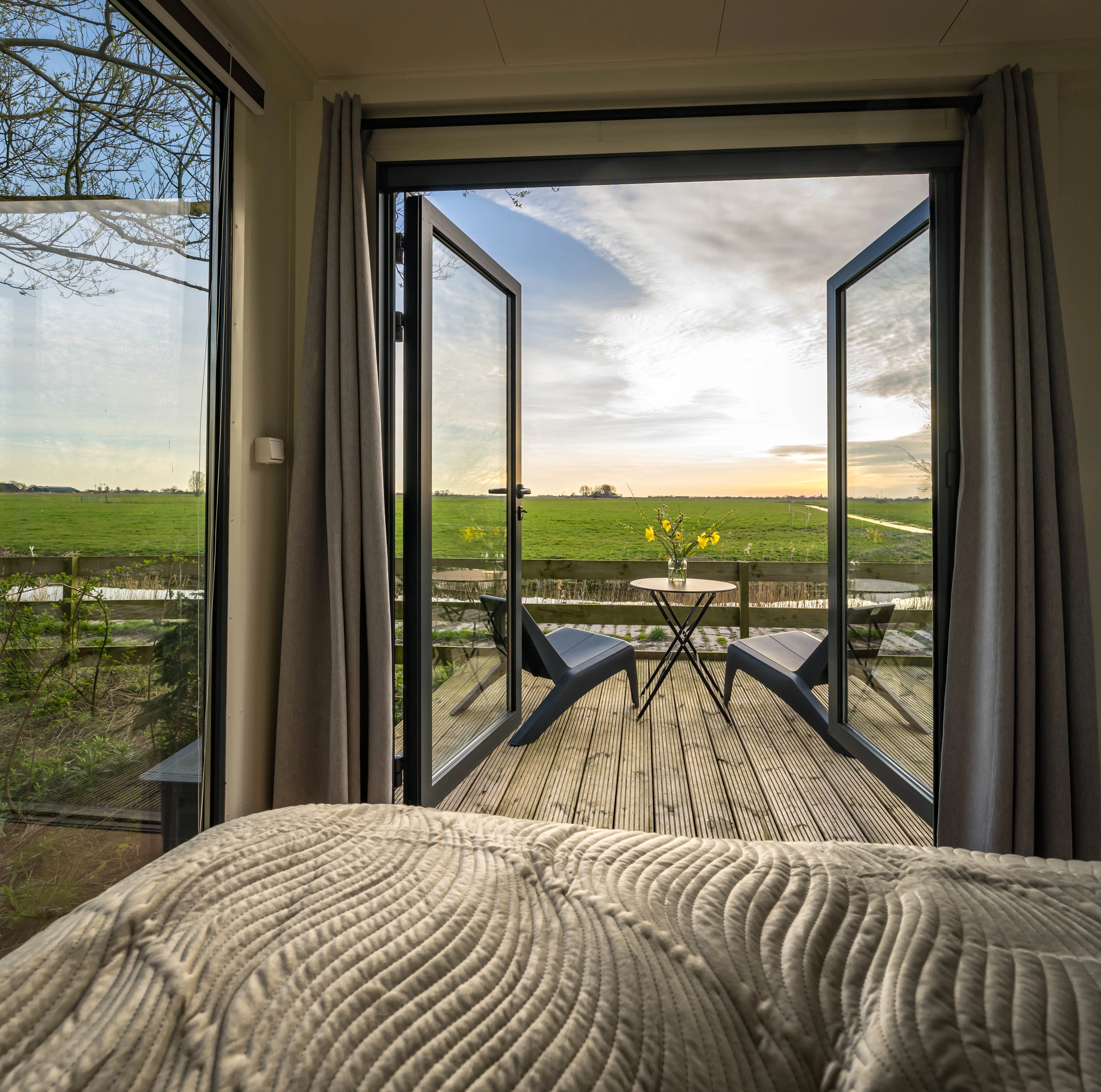 Slaapkamer met zicht door de openslaande deuren naar het terras